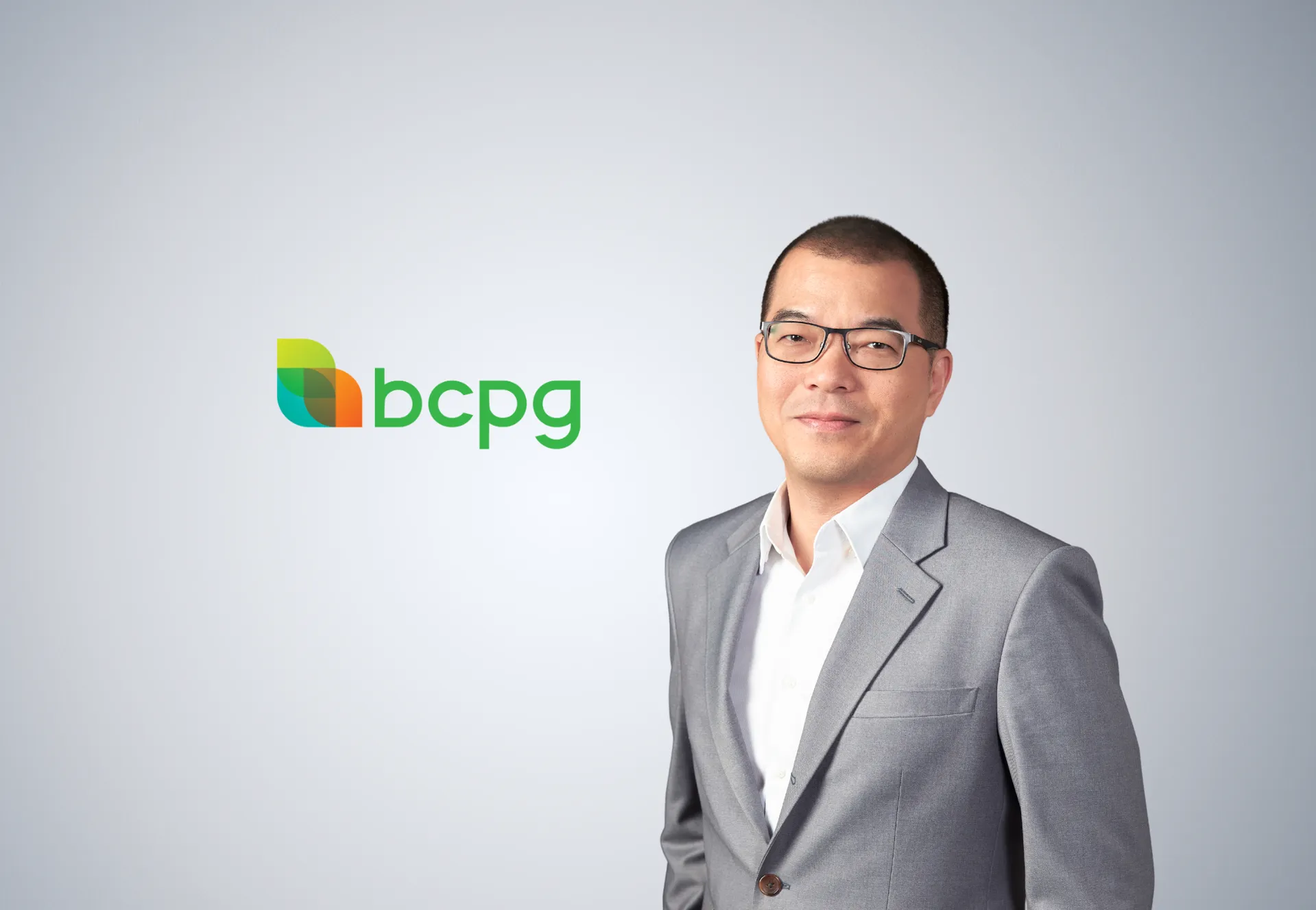 ผู้บริหารชายสวมสูทสีเทาและแว่นตายืนยิ้มข้างโลโก้บริษัท BCPG บนพื้นหลังสีเทาอ่อน ประกอบข่าวผลประกอบการครึ่งปีแรก 2569 ที่มีกำไรเติบโต 146%