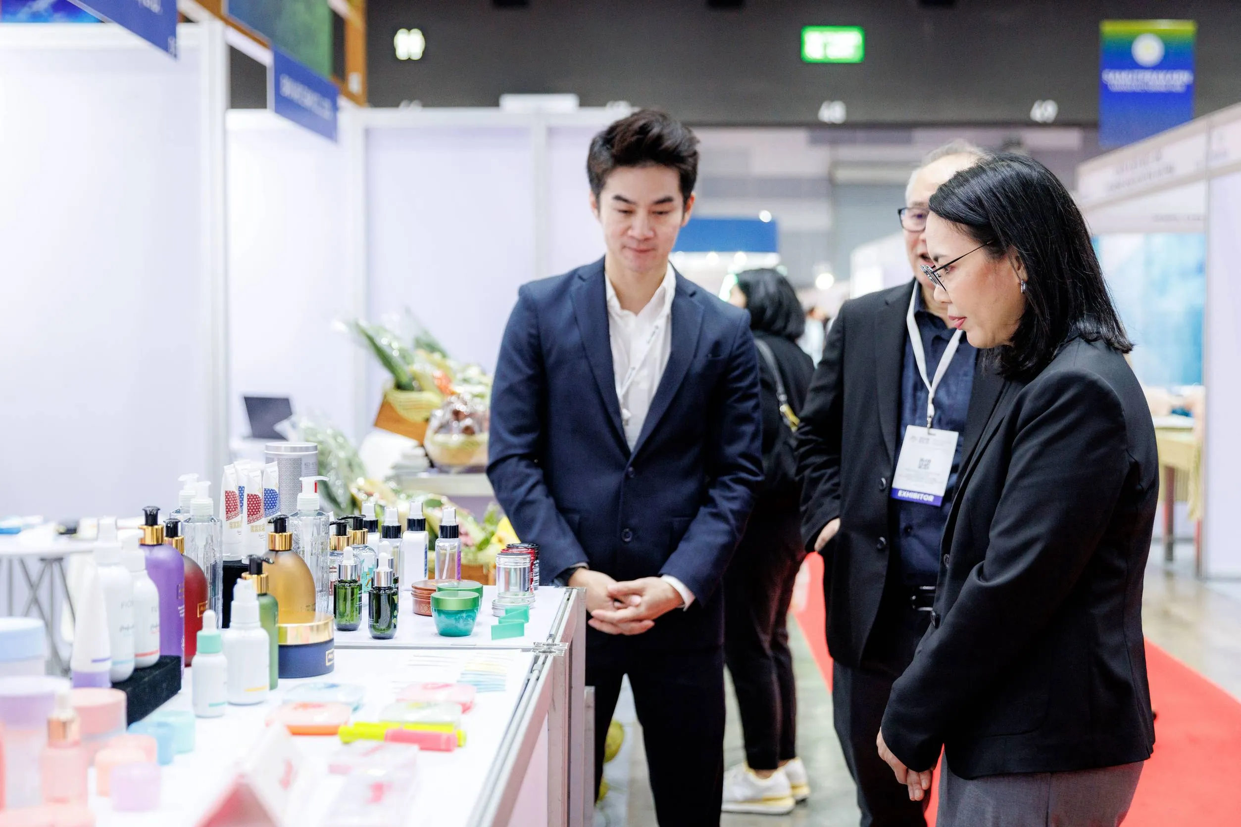 ผู้เข้าร่วมงานแสดงสินค้าสนทนากับผู้ประกอบการที่บูธจัดแสดงผลิตภัณฑ์เครื่องสำอางและความงามของ SME ไทยในงานแสดงสินค้า สสว.