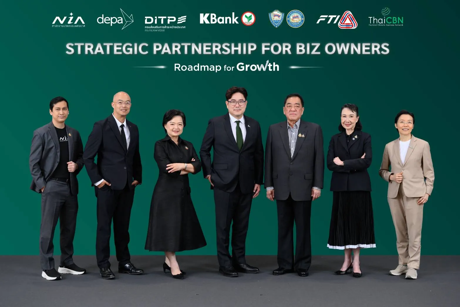 ภาพผู้บริหารจาก 7 องค์กรพันธมิตร ได้แก่ NIA, depa, DITP, KBank, กระทรวงพาณิชย์, FTI และ ThaiCBN ยืนเรียงแถวถ่ายภาพร่วมกันในงานเปิดตัวโครงการ "Strategic Partnership for Biz Owners: Roadmap for Growth" บนพื้นหลังสีเขียว