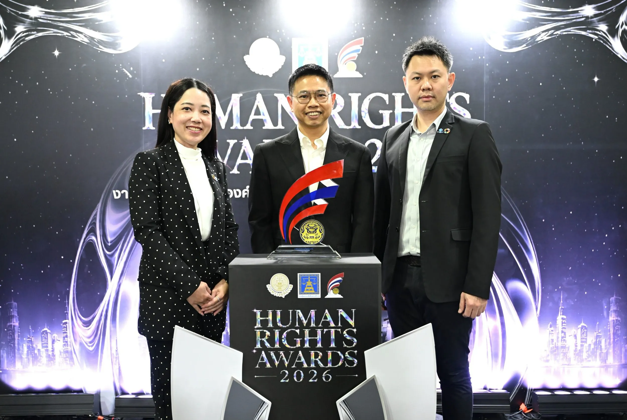 ผู้บริหาร EASTW สามคนถ่ายภาพร่วมกับถ้วยรางวัลบนเวทีงาน Human Rights Awards 2026 เนื่องในโอกาสได้รับรางวัลองค์กรต้นแบบด้านสิทธิมนุษยชนต่อเนื่องเป็นปีที่ 4