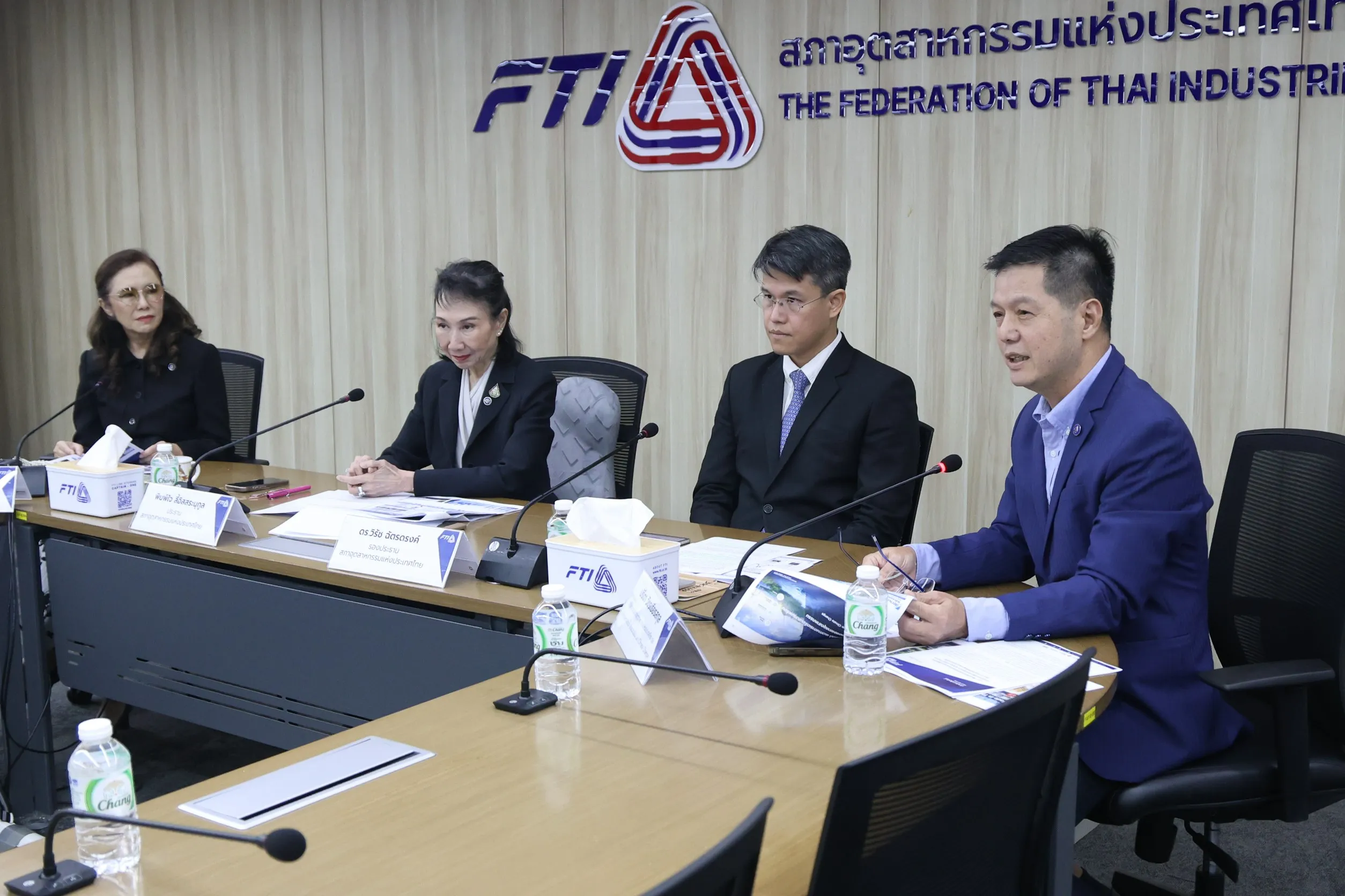 ภาพผู้บริหารสภาอุตสาหกรรมแห่งประเทศไทย (ส.อ.ท.) 4 ท่านนั่งแถลงข่าวร่วมกันที่โต๊ะประชุม พร้อมไมโครโฟนและเอกสาร ภายใต้ป้ายโลโก้ FTI บนผนังด้านหลัง ในการแถลงข่าวเรื่องผลกระทบจากอุทกภัยปี 2569 ต่อภาคอุตสาหกรรม