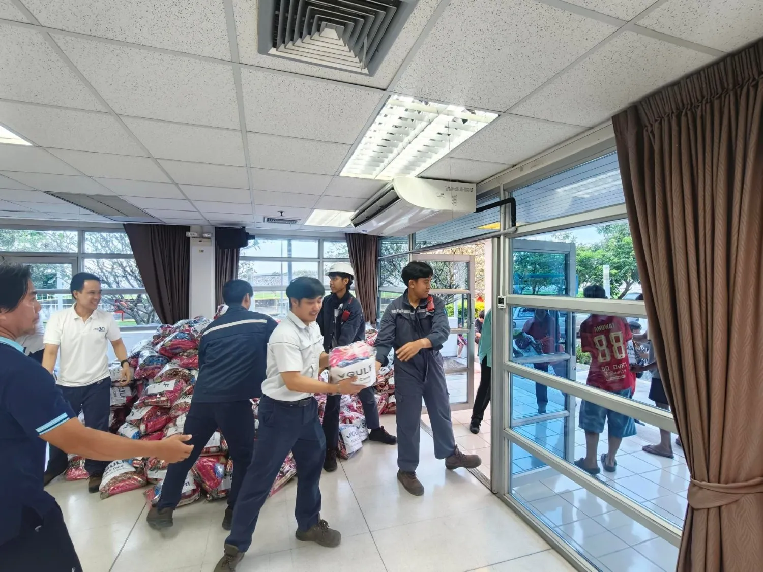 พนักงาน GULF Care ร่วมกันขนย้ายถุงยังชีพกองใหญ่เพื่อเตรียมส่งมอบให้ผู้ประสบภัยน้ำท่วมในพื้นที่ต่าง ๆ